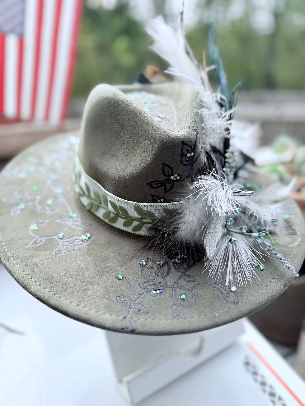 Miniatura: Front view of the olive suede Tree of Life custom hat with decorative crystals and feathers