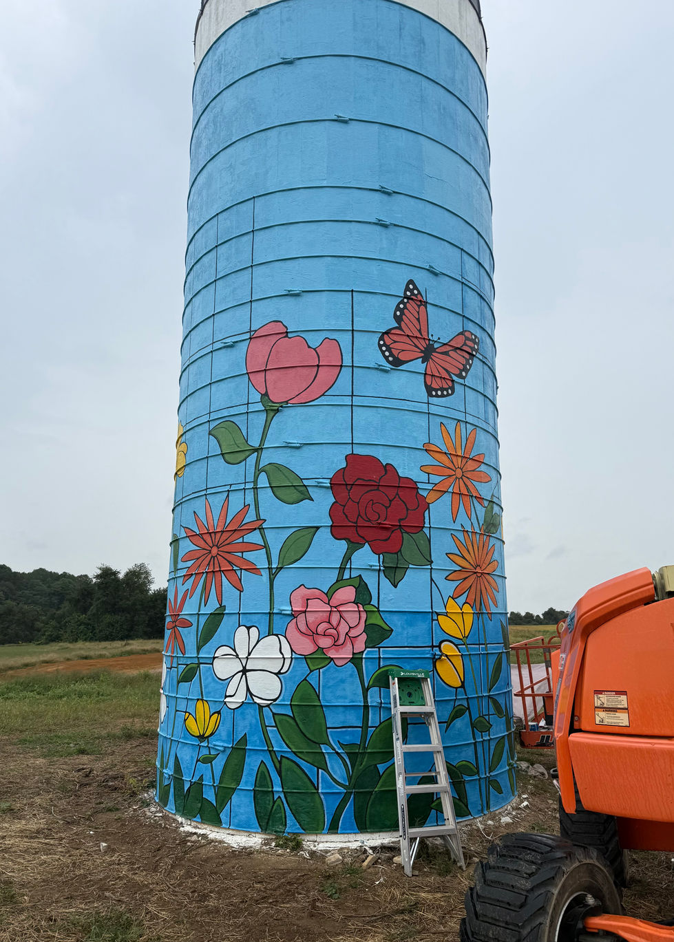 image of a Mural being painted on the sides of a silo