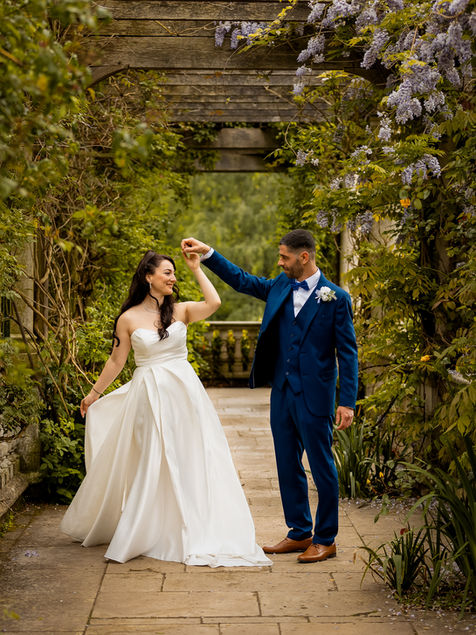 A bride twirling in her dress at Pergola Garden Hill, London, with the groom holding her hand in a romantic dance