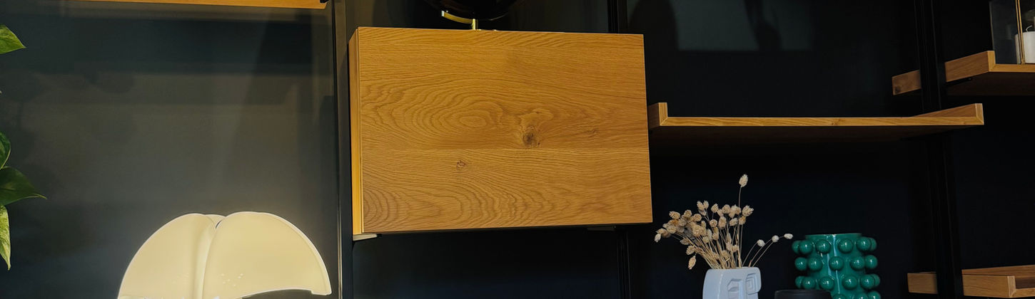 Meuble bibliothèque sur mesure en bois et noir, rénovation de grange avec décoration raffinée.