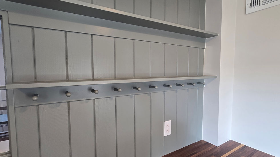 Olive shelves and hooks on olive wall