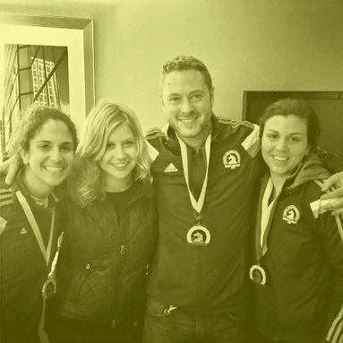 Jess smiles with three friends after finishing the Boston Marathon
