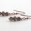 Thumbnail: Amethyst Three-Sided Window Bead Earrings - laying flat - Czech glass, ornate metal lantern beads in antique copper color