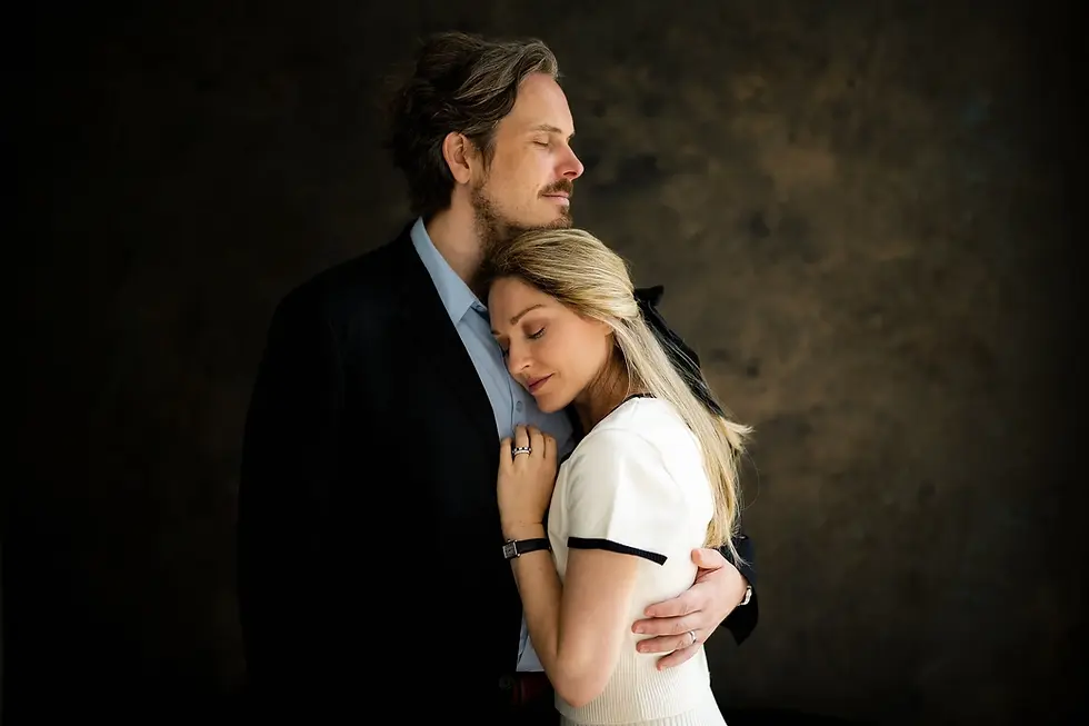 Couple embracing, with one partner resting her head against the other’s chest.