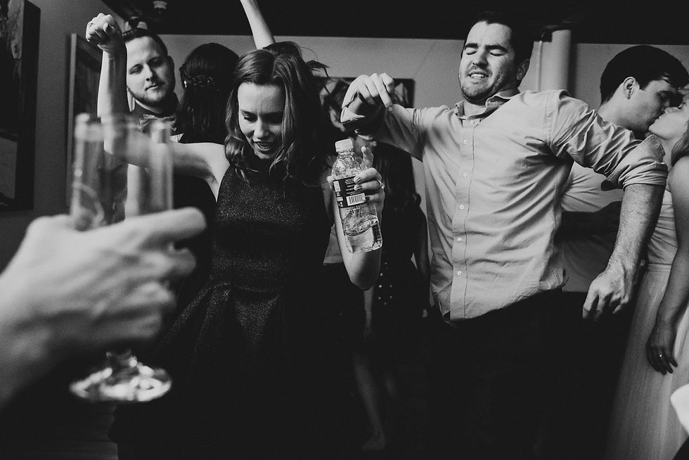 Guests dance with drinks and raise their hands