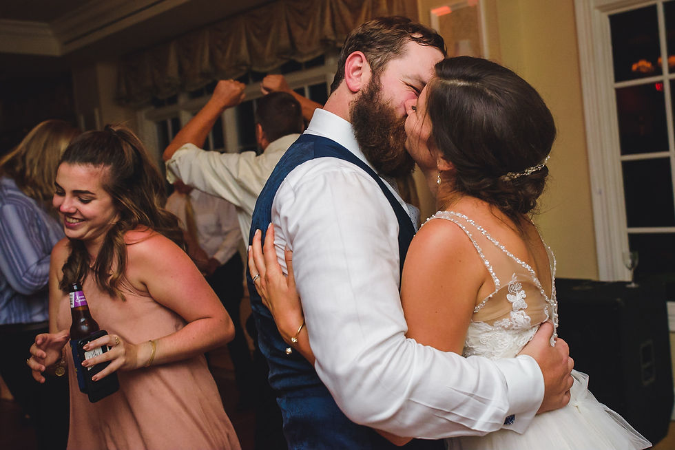Newlyweds kiss while dancing at the reception