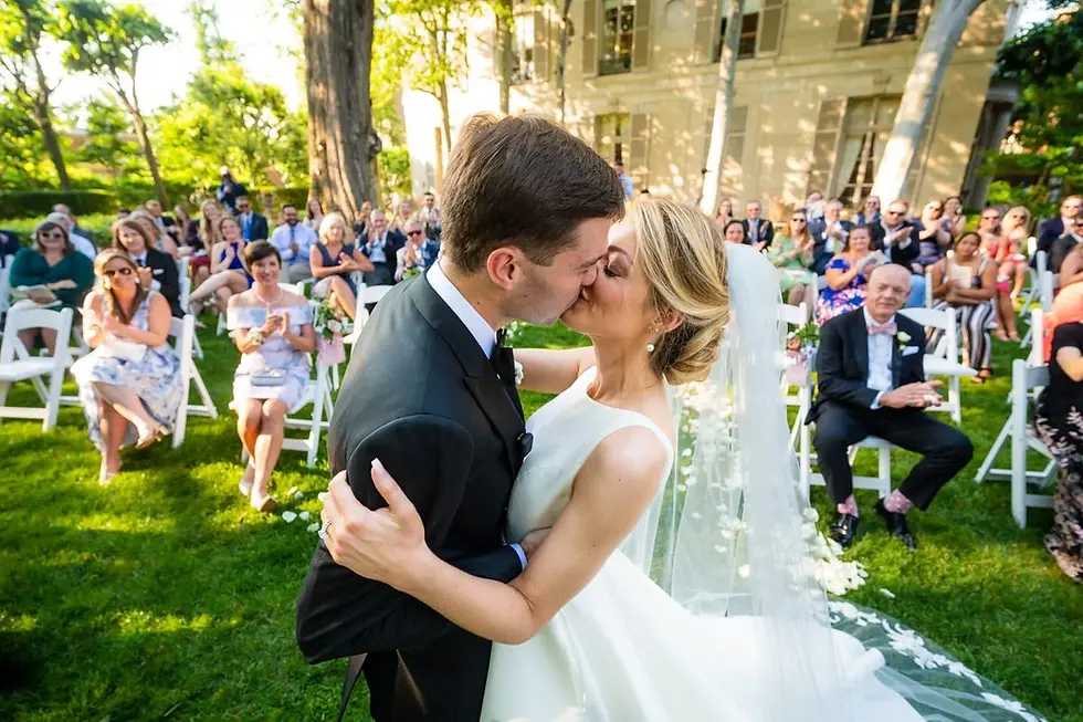 Bride and groom kissing at an outdoor ceremony.