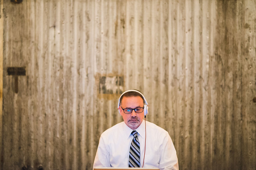 A man wearing headphones and a striped tie at the wedding reception