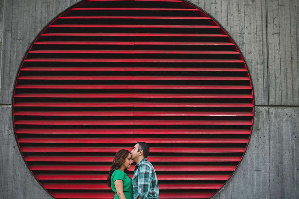 Couple embracing beneath a circular red architectural feature