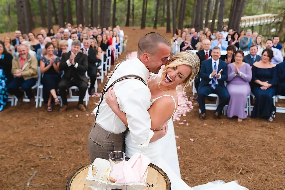Bride and groom laughing together during an outdoor ceremony.