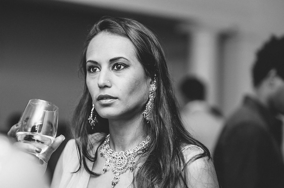 Black and white portrait of a wedding guest holding a drink