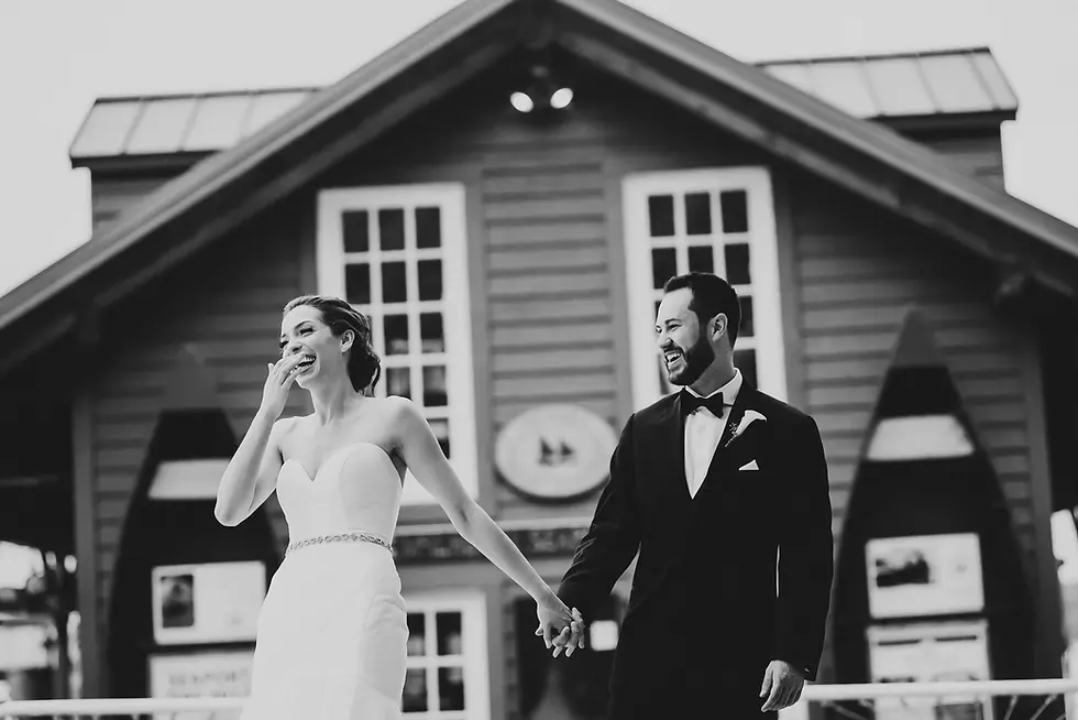 Bride and groom laughing together outside a building.