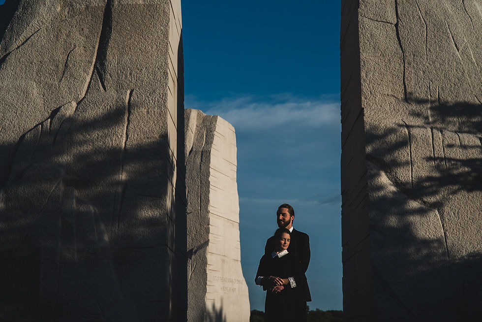 Couple framed between tall stone walls during a National Mall engagement session.