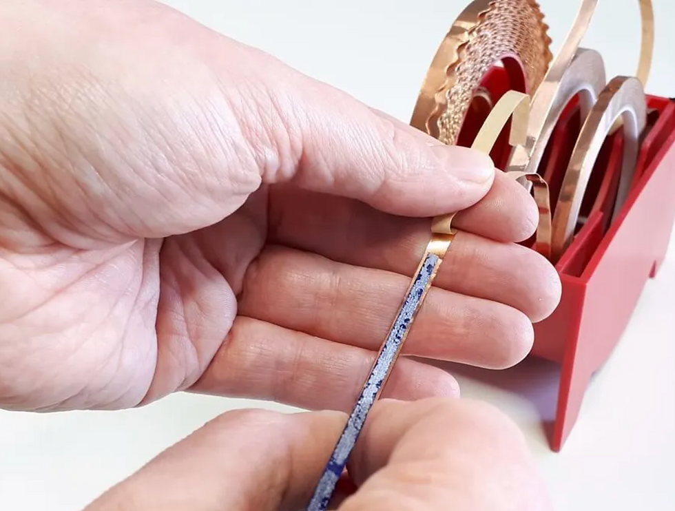 hand peeling copper foil from a roll