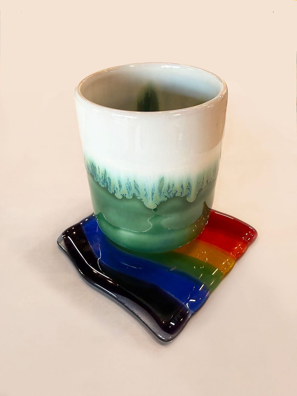 mug resting on top of a rainbow colored fuse glass coaster