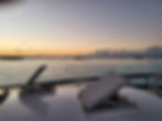 Sunset view from a trawler photo gallery deck over calm water.