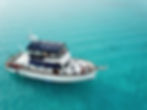 Trawler photo gallery featuring a white boat on clear water