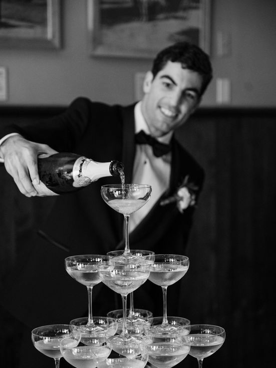 photo of groom pouring champagne on champagne tower taken by Maria Gloer Photography nashville wedding photographer