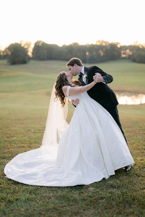 Bride and groom kissing during sunset portraits at their Nashville tented wedding