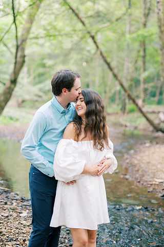 couple embracing on creek for engagement photos taken by Maria Gloer Photography Nashville wedding photographer