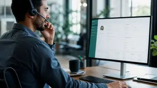 A sales rep taking a call at a Zoho CRM screen in a modern office