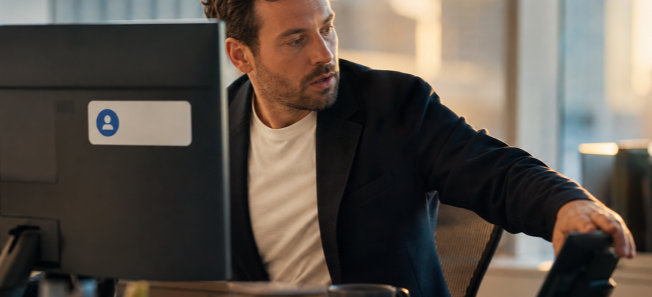 A salesperson at a desk reacting to a real-time notification popping up on screen, reaching for the phone