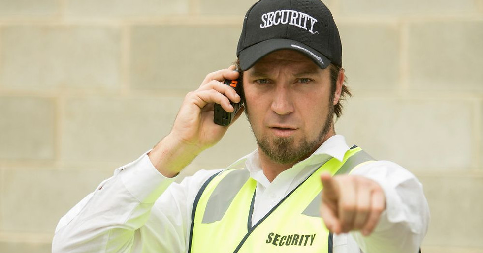 Security guard in vest talking on radio, pointing