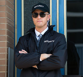 Security guard in sunglasses standing with arms crossed