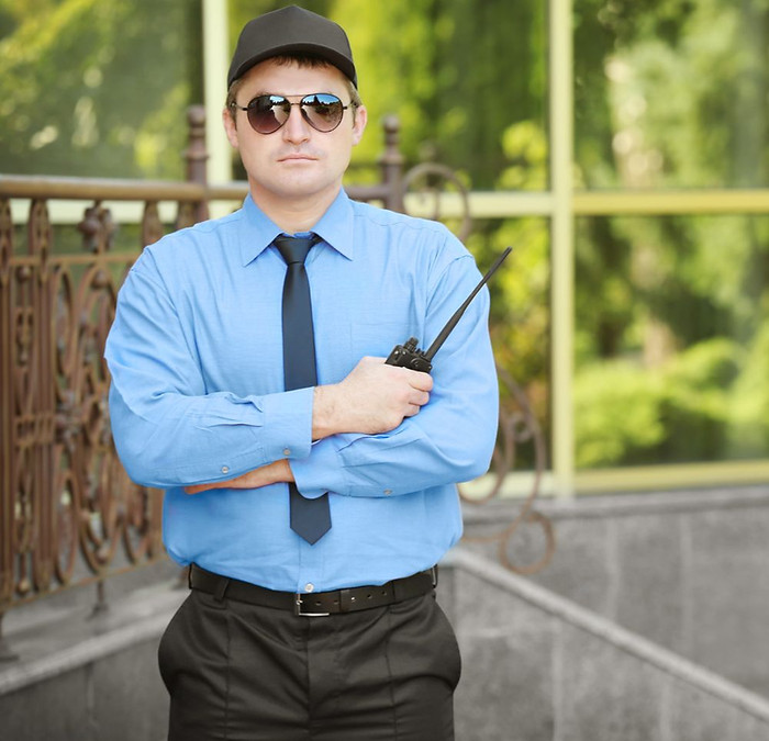 Security guard standing watch outside modern residential building