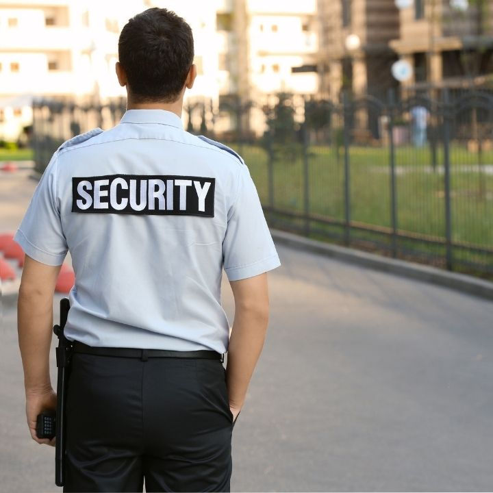 Security guard patrolling residential neighborhood inside gated community.
