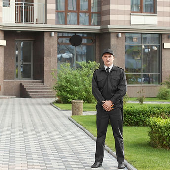 Sunglassed security officer holding radio, standing confidently