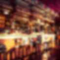 Colorful bar interior with stools and glass shelves.