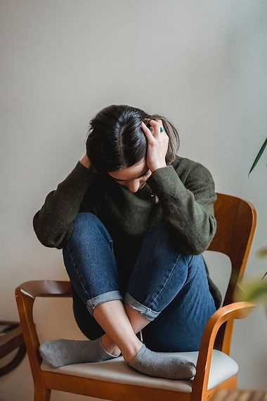 woman in chair with head in hands