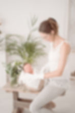 Ein Foto zeigt Saskia Rachor, wie sie behutsam ein Baby für das Neugeborenenshooting positioniert.