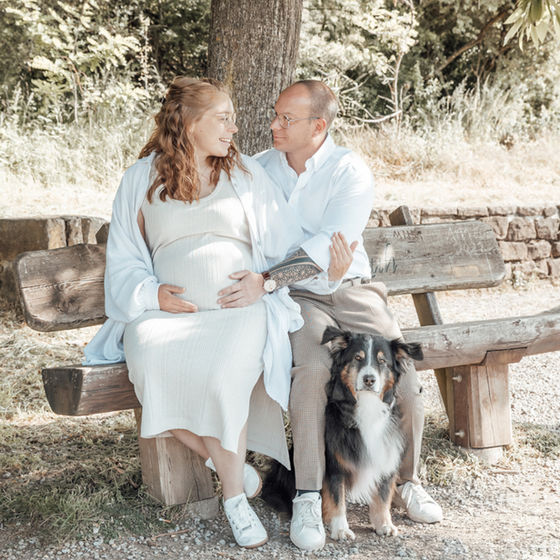 Babybauch-Shooting: Paar mit Hund auf Parkbank