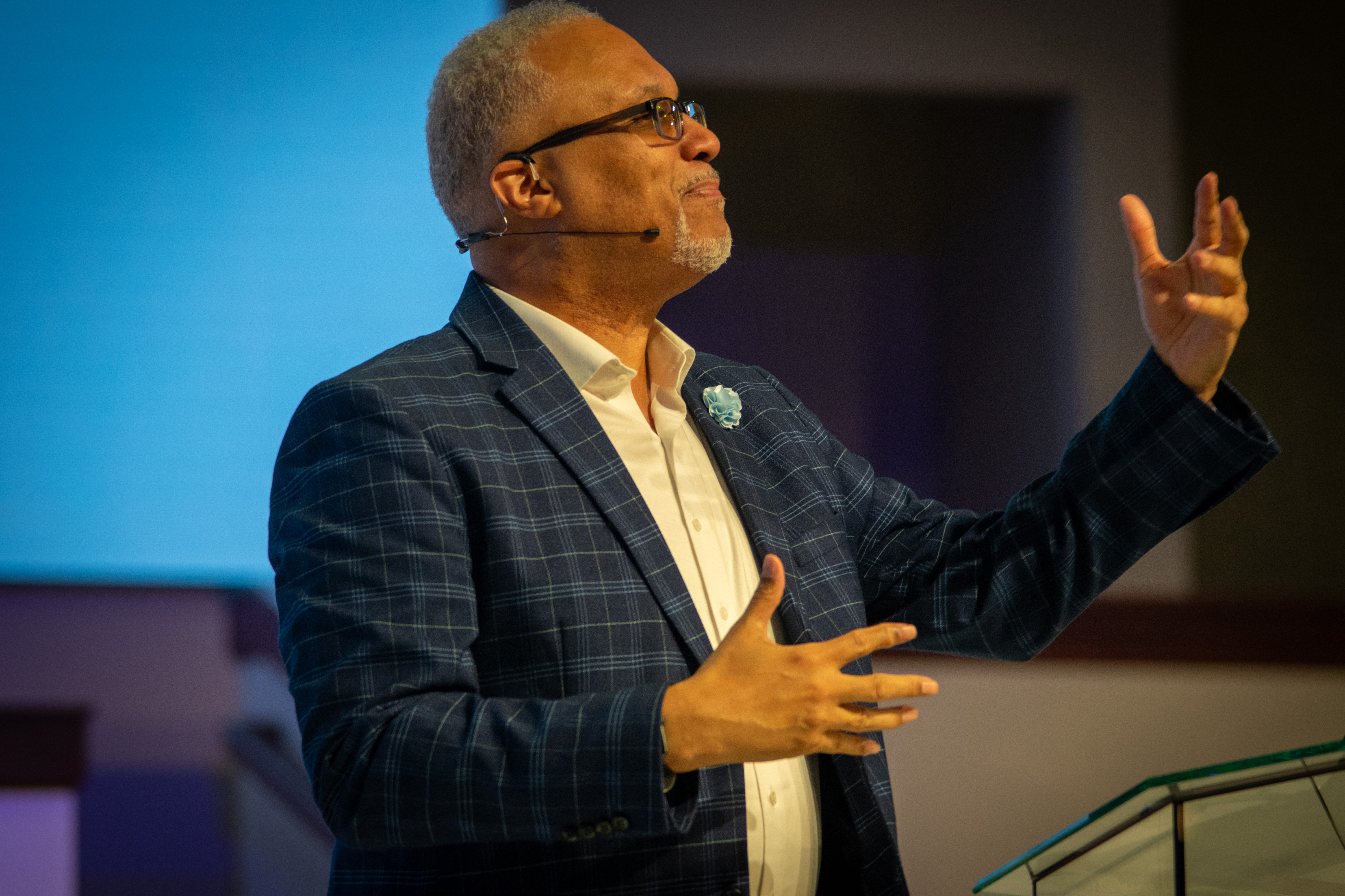 Larry Walters speaking during a men's gathering with one hand raised toward the audience