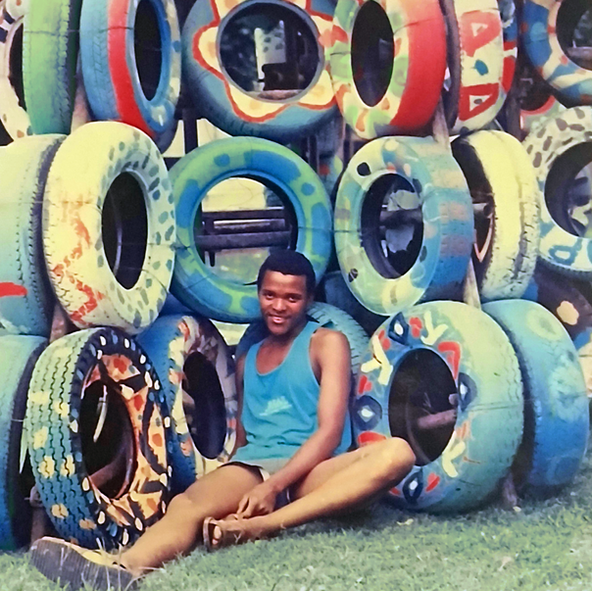 A portrait of Themba Sokhulu from Sawubona Youth Trust sitting in front of the completed Peace Tree.