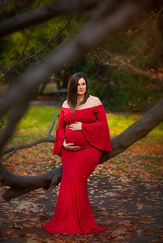 maternity session woman in a red dress holding a belly