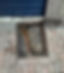 A rectangular manhole cover is partially open