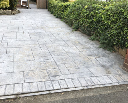 A paved driveway with a textured, light gray surface
