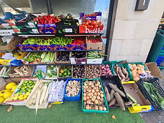 Fresh produce display outside a market with colorful vegetables and fruits