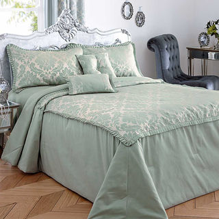 Elegant bedroom with an ornate silver headboard, light green damask bedding
