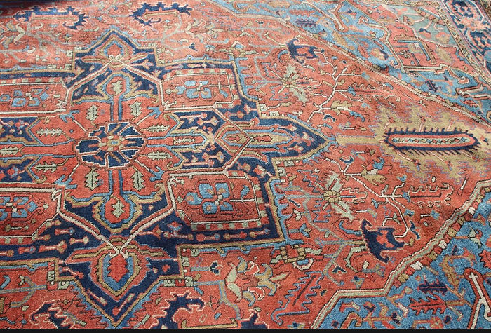 Intricate Persian carpet design features a central geometric pattern