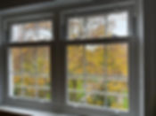 multi-panel window with a view of trees and a garden beyond