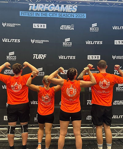 Four people in bright orange shirts stand back-to-camera