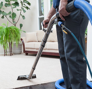 Man cleaning carpets in home