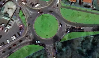 Aerial view of a roundabout with a green grassy center