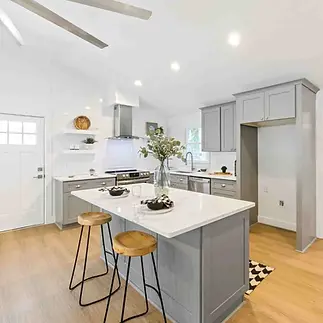 Bright, modern kitchen with gray cabinets, white countertops, and light wood flooring