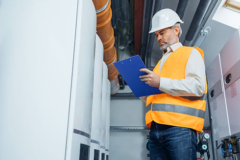 A man inspects boiler in an industrial setting