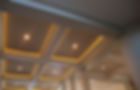 A coffered ceiling with warm recessed lighting and modern downlights